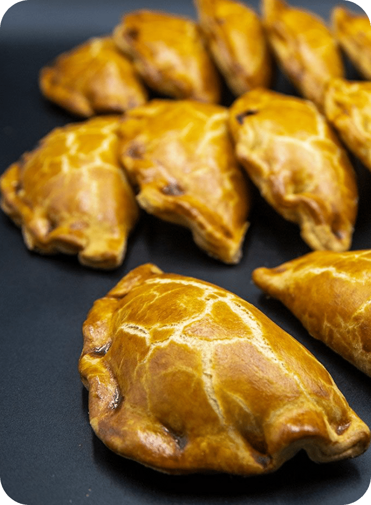 Varias empanadillas sobre una tabla de pizarra.