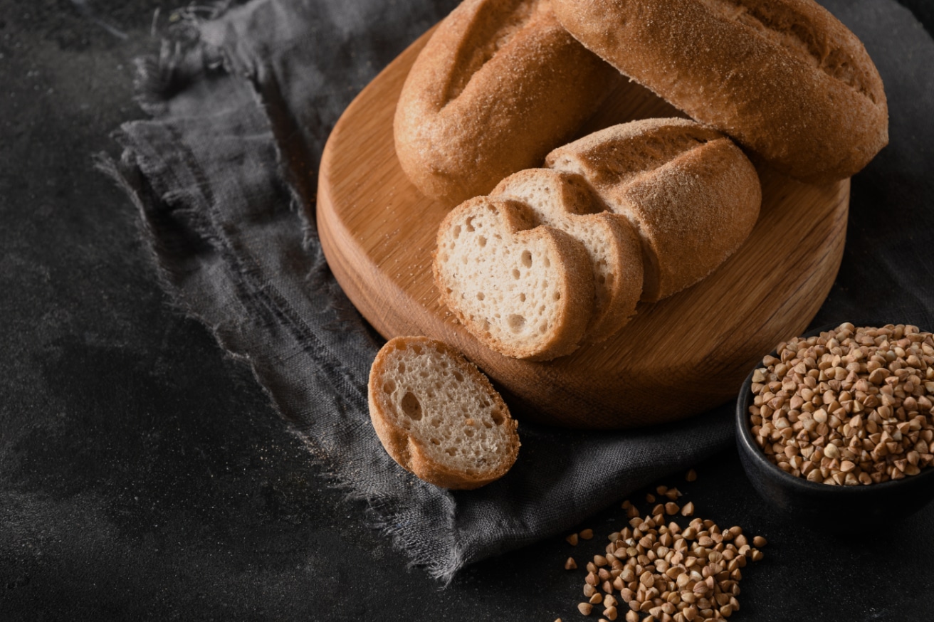 Pan y trigo sin gluten en tabla de madera. El sabor artesanal ahora sin gluten